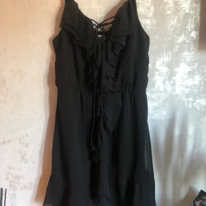 Kort svart klänning - Strl 38 Knytning fram så man kan bestämma själv hur urringningen ska vara
