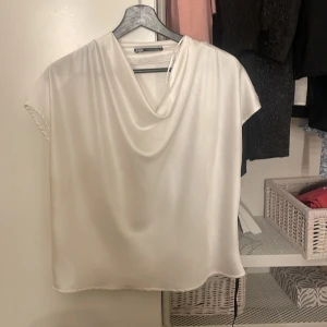 Vit blus  - Vit plus från Sara med lösare typ upptill. 