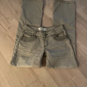 Jeans  - Skit snygga lågmidjade jeans med glittriga detaljer på. Jeansen är bootcut.   Midjemått - 36 cm Innerbendlängd - 81 cm Ytterbenslängd- 104 cm   Säljer då de tyvärr var för små. Pris kan diskuteras 