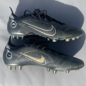Nike Mercurial Vapor 14 Elite AG - Säljer dessa fotbollsskor. Använda ett par matcher och därmed lite slittna dobbar (bild 3) annars väldigt väl omhändertagna. Riktigt sköna och bekväma på foten. Om andra eventuella frågor är det bara att fråga på :)