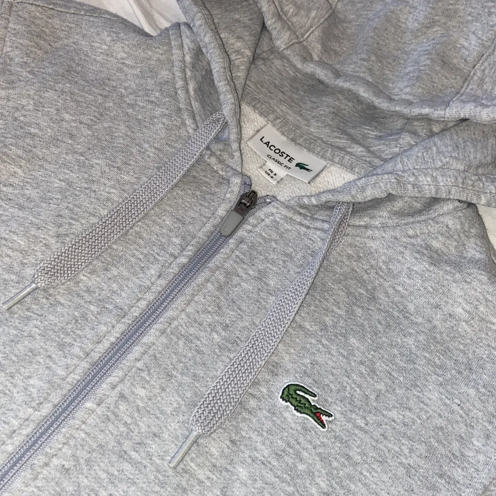 En Lacoste huvtröja storlek S 10/10 skick fickor med dragkedja och innerfickor finns på hoodien. . Hoodies.