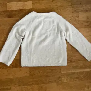 Säljer denna vitglittriga stickade tröjan med slus på sidan💞