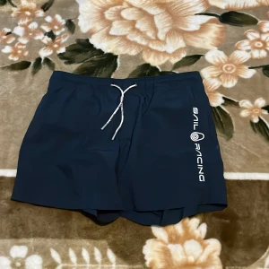 Sail racing badshorts - Mörkblåa Sail racing badshorts köpta för 500kr säljer nu för halva priset då jag har vuxit ur dem och använt dem endast ett par gånger då jag har köpt nya.  Mvh!
