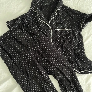 Svart pyjamas med prickar - Jättesöt svart bomulls skjortpyjamas med vita prickar i storlek S. Använd 1 gång. Perfekr o skön året om❤️pris kan diskuteras 