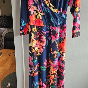 Långklänning - Vacker blommig långklänning säljes. Använd endast vid 1 tillfälle. Snyggt fall. 