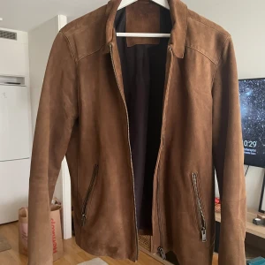 Brun mockajacka i nyskick  - Sparsamt använd. Inga defekter.  Äkta mocka   Från djur- och rökfritt hem   Kragen har blivit omsydd av skräddare för en snyggare look