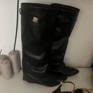 Svarta Boots trendiga med guld detalj - Säljer mina fina svarta boots som inte kommer till användning. Använt 2 gånger och det är super bekväma. Ca 8cm klack, med dragkedja som är gömd. En liten guld detalj upp till. Skriv för fler bilder! Storlek 39/40 skulle jag säga. 