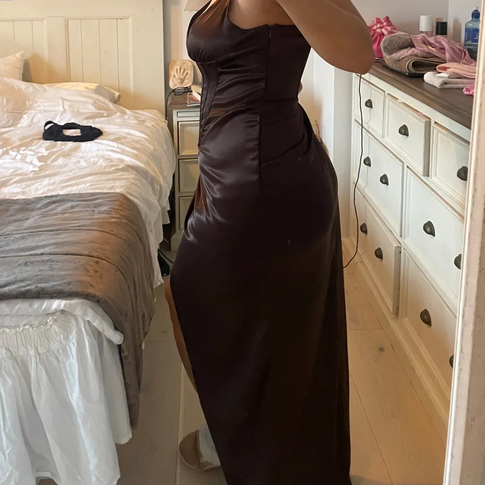 Mörkbrun sexig balklänning från NAKD. I helt nytt skick, aldrig använd, lappen av köpet är kvar. Storlek 42. Lite stor, men största anledningen för försäljning är att jag inte kommer använda den. Vid intresse kan priset diskuteras. . Klänningar.