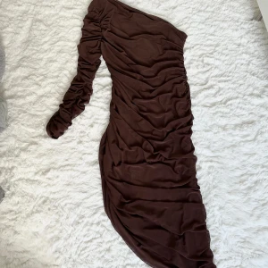 Klänning - Klänning i mesh i någon rödbrun färg, aldrig använd
