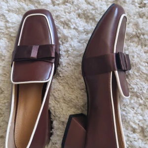 Bruna pumps - Säljer superfina bruna pumps med vita detaljer. 🎀 Använda bara en gång (Lite stora på mig)