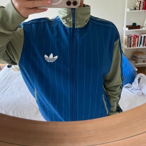 Adidas track jacket - En grön och blå track jacket i storlek M. Köparen står för frakt🥰