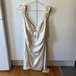 Oanvänd adooreklänning - Aldrig använt, därmed som ny. Den är i strl 36, i färgen off-white.