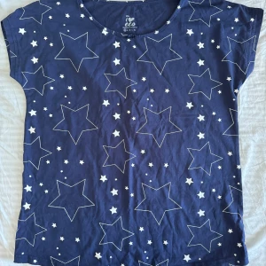 T-shirt  - Blå T-shirt med vita stjärnor, knappt använd, strl xs