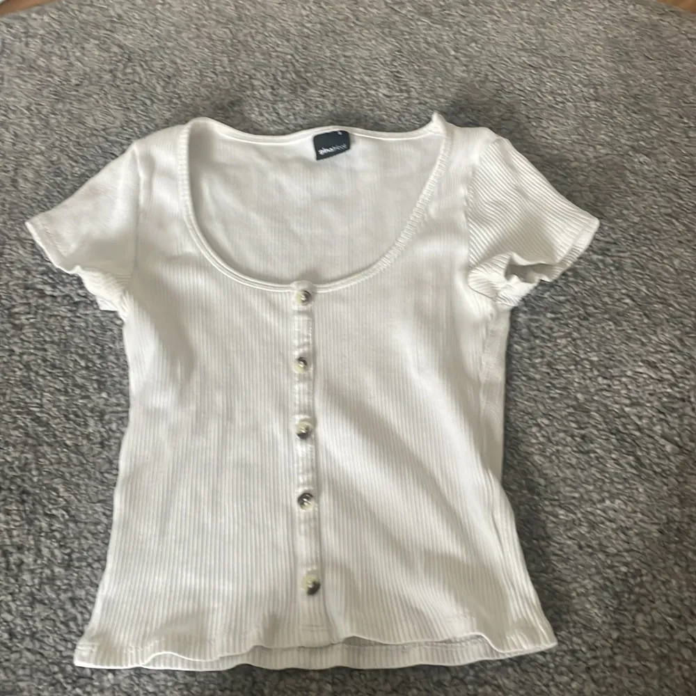 vit t shirt med knappar från Ginatricot, i nyskick. Storlek S men passar XS. köpt för 189 säljes för 70. T-shirts.