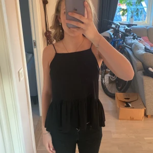 Volang linne - Ett svart linne med volang i bra skick. Ord pris 150kr