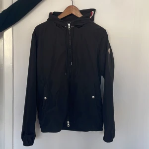 Moncler windbraker - Säljer denna feta Moncler jackan, skick 6/10, en liten defekt på snöret vid luvan annars bra, perfekt nu inför våren