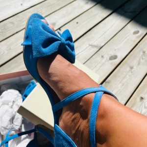 Sandaler - 👠 BLÅA SANDALER MED ROSETT   Har köpt dem i Köpenhamn för 1800 kr.  Kom aldrig till användning. Helt nya. Klackhöjd 8 cm. Storlek: 39 Märke: Copenhagen shoes 