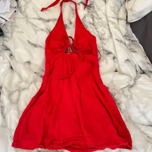 Supersnygg röd klänning med knyte i nacken och en öppen rygg