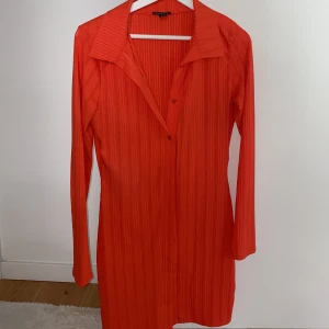 Lång kofta/klänning figurnära  - Neon orange jätte snygg koft/klänning med knappar som kan bäras med knappar och utan! Figurnära och liten i storlek. 42 mer som en 40! 