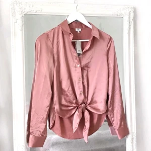 Rosa blus XS River Island NY!! - Färg: Rosa.  Strl: 6/XS.  Snygg blus från River Island. Helt NY med lappar kvar. Dvs helt oanvänd. Knapp-knäppning framtill. Samt twist-dekor framtill.  Kommer ej till användning och stor garderobsrensning pågår!