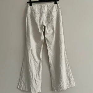 Utsvängda linnebyxor - Utsvängda linnebyxor med snygga detaljer. De är lågmidjade och har en innerbenslängd på 79cm. Bra skick! Perfekta till sommaren!☀️🤩Hör gärna av dig om du vill ha fler bilder eller har några frågor!☺️