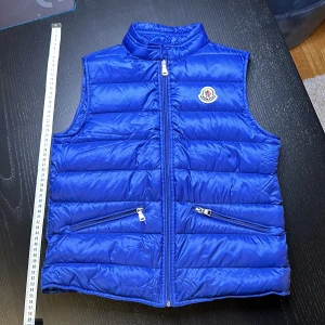 Mocler vest  - En äkta Mocler vest från NK. Den är använd men fortfarande i bra begagnat skick. Säljer den för att jag har växt ur den. Nytt pris 3 185kr på Moncler hemsida.