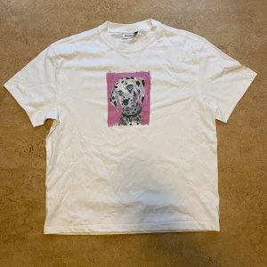 Vit Weekday T-shirt med print - Vit Weekday t-shirt i storlek M. Bra skick, inte använd så mycket. Är något uppsydd och därmed lite kortare.