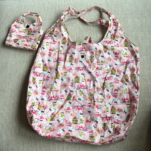 Shoppingpåse Hello Kitty - Praktisk och söt shoppingpåse som är lätt att ta med sig på shoppingrundan. Hopvikbar med liten väska med knapp. 