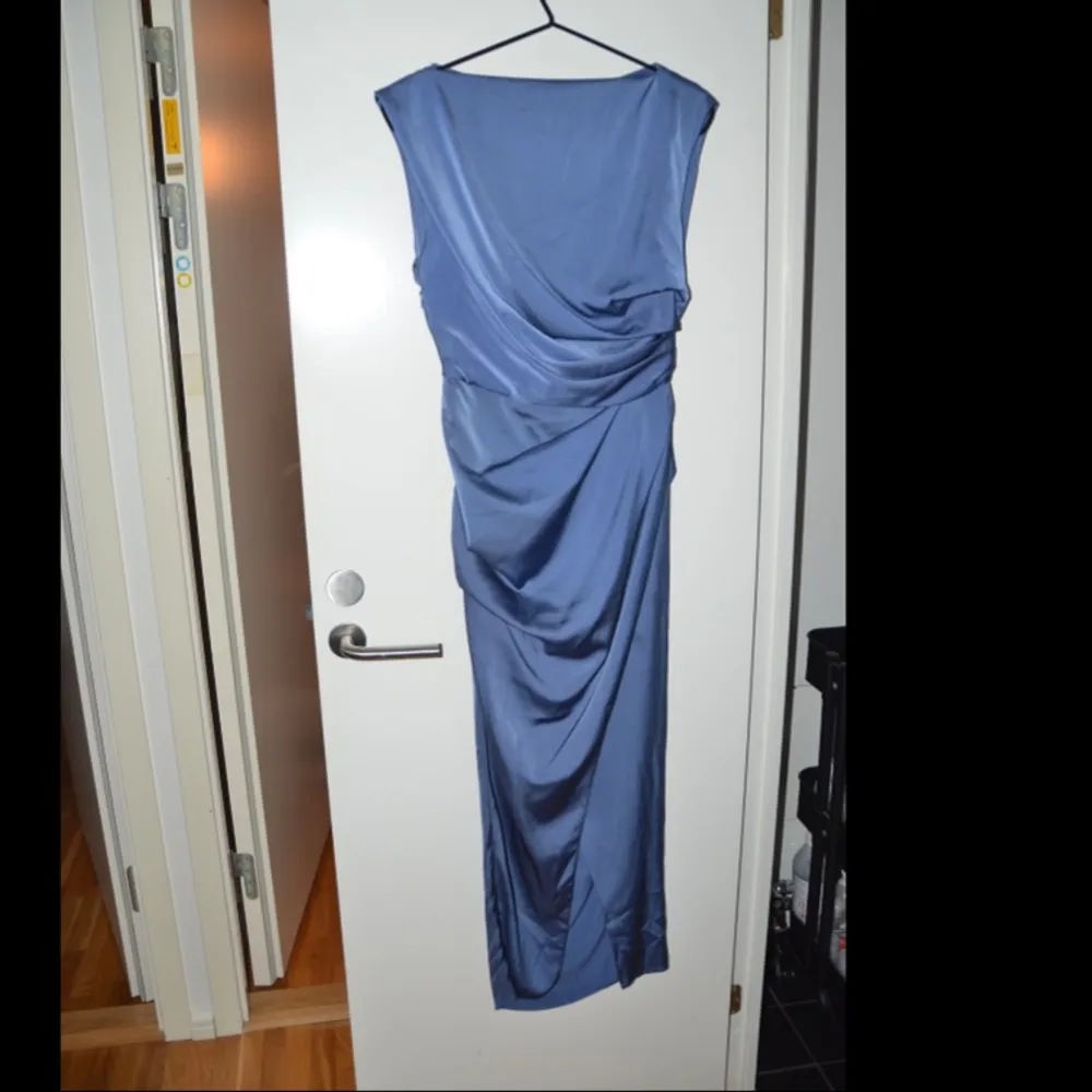 Lila/blå satin klänning med öppen rygg och slits på framsidan. Klänningen formar och tar fram ens kropp till det bästa. Perfekt balklänning om du frågar mig!😍💕  Aldrig använd pga för liten, prislappen kvar . Klänningar.