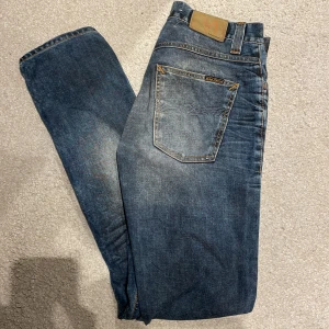 Nudie Jeans grim tim - Säljer ett par Nudie Jeans i modellen grim tim. Storleken är 32/34 och färgen är ”used blackcoated”. Säljer då de tyvärr är aningen långa på mig, är 182.