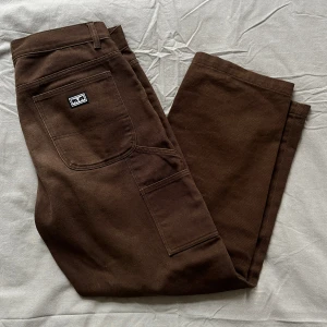 OBEY, Byxor, Bruna, L - Sköna, lose fit OBEY-byxor med lite stretch och klassiska sidofickor.  Storlek 32 men skulle säga att midjan är ca 33