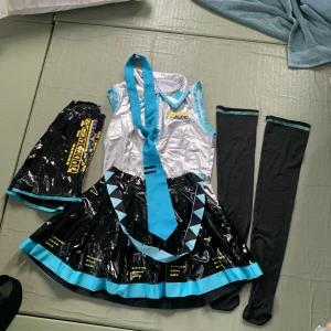 Hatsune miku cosplay - arms supported by saftey pins to fit arm size. Belt and tie has a few small stain that are barley noticeable. Worn about 10-20 times.