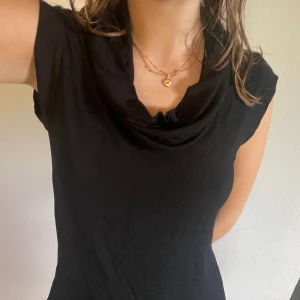 Klänning - Knälång klänning med din detalj runt halsen. I bra skick. Storlek M