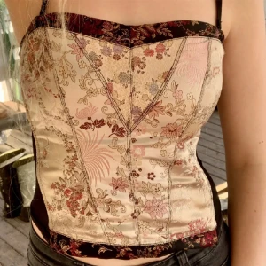 Korsettopp  - Supersöt korsettopp. Axelbanden går att ta av, det finns stretchiga mesh på sidorna och 2 rader med hakar så man kan bestämma hur tajt den ska sitta. Små täcken på användning men inget som märks. 💕