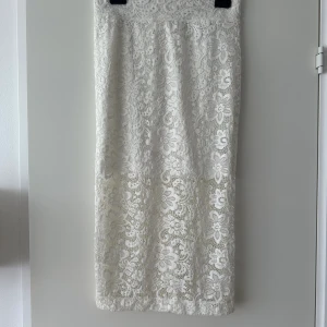 Spets kjol - Jättefin blommig spets kjol med en liten slits där bak, passar perfekt till tex midsommar. Har ett undertyg som går ner till hälften av kjolen. Aldrig använd. 