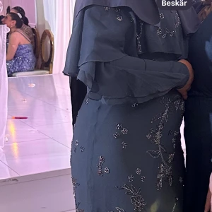 Lång klänning i grön/grå färg - Fin lång klänning använd endast en gång på ett bröllop, strl M, god skick, köpt för 1489 kr på asos säljer för 600 