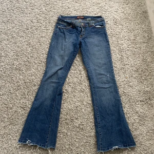Lågmidjade bootcut jeans - Lågmidjade bootcut jeans köpt secondhand. I bra skick men har sprättat upp längst ner för att de skulle bli längre.  Har ett hål på vänstra knä (ingen defekt utan modellen) midjemått:38cm tvärs över innerben:78cm Pris kan diskuteras