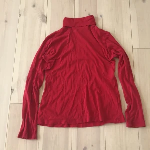 Röd turtleneck - Säljer denna snygga röda turtleneck tröjan då jag inte använder den längre❣️. Är i använt men fint skick och inga skavanker förutom ett pyttelitet hål som knappt syns på framsidan💞.