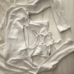 Crop top med öppenrygg  - Vit coolt top med snörning i ryggen  Använd men är fortfarande du fint skick Kan även skicka eller mötas upp  