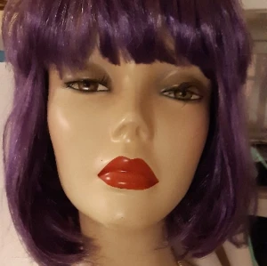 Lila peruk - Lila peruk. Möjligen använd några gånger för jättelänge sen. I fint skick. Kamma och tvätta, frosera som du vill. Syntet.
