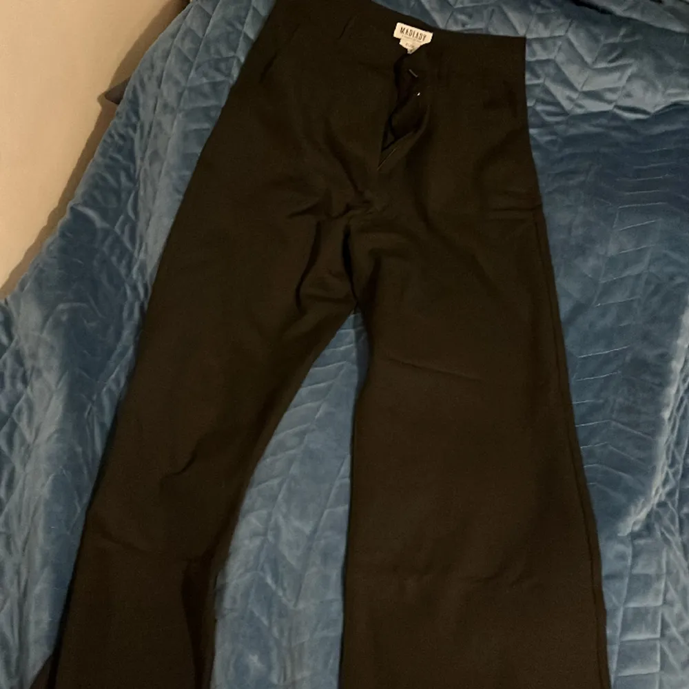 Dessa kostymbyxor i mid waist är raka i modellen. De har bälteshållare och en ficka på varje sida.   Bästsäljare, storleken är slut i lager. . Jeans & Byxor.