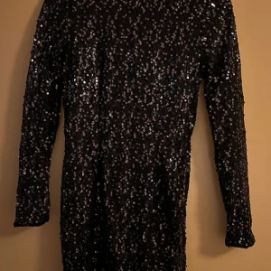 Mörkblå festklänning paljetter  - Mörkblå festklänning från Gina Tricot i fint skick. Använd 1 gång. På bild 2 är det klänningen till vänster (den andra är svart)