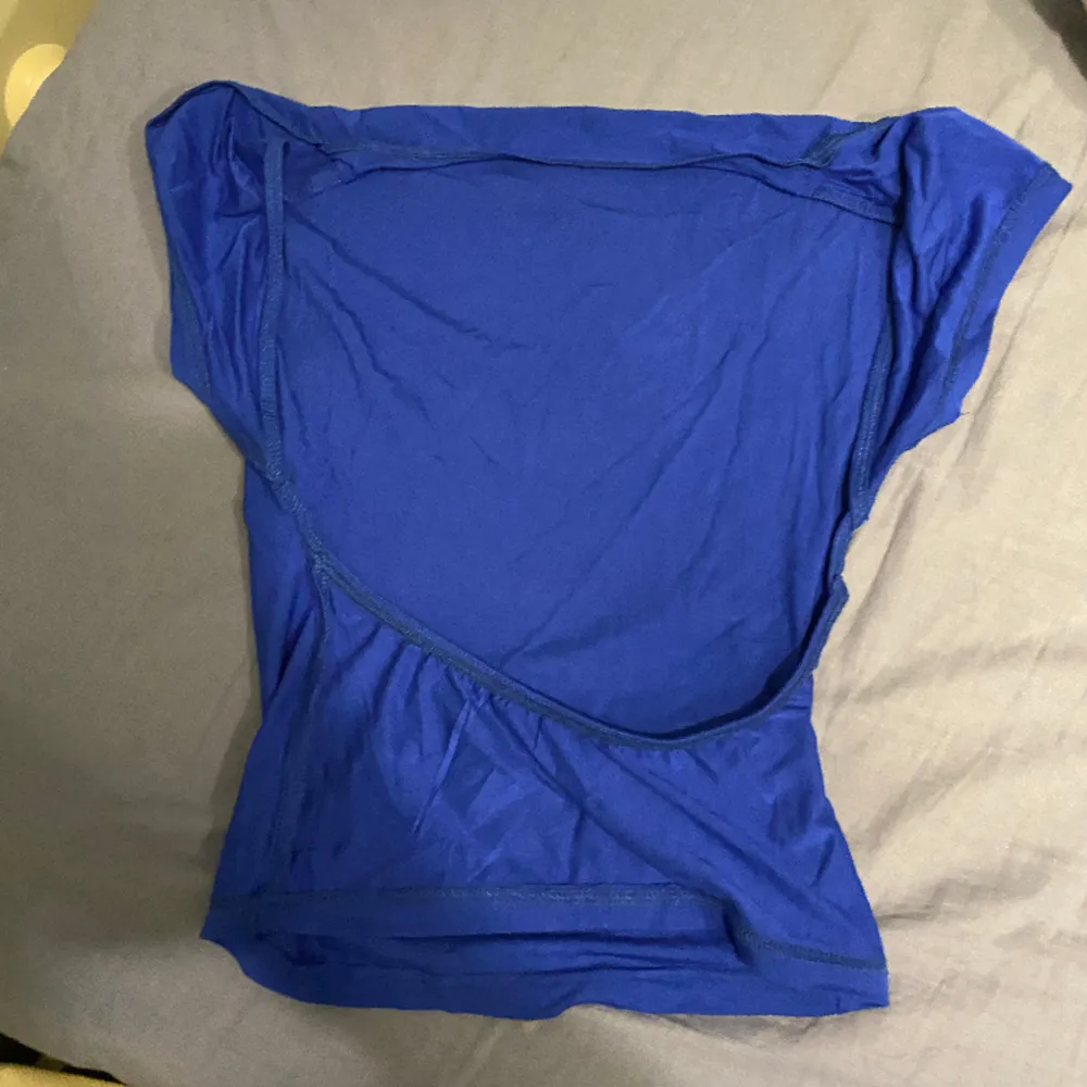 blå t shirt med öppen rygg jätte snygg men aldrig kommit till användning . T-shirts.