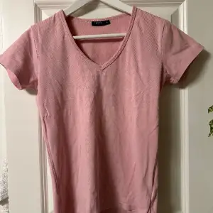 V-ringad T-shirt i puder rosa. Stl. S