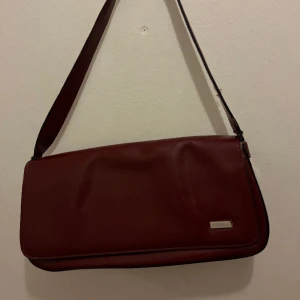 Vintageväska fiorelli - Väska från fiorelli i snygg röd färg köpt second hand. Defekter syns på bild 3