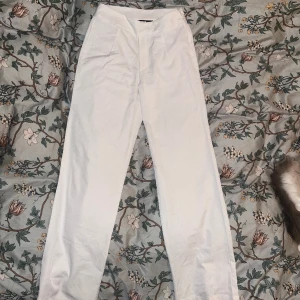 Vita ”kostym”byxor från Bikbok🎀 - Snygga tunna byxor från bikbok🩷 Inget fel på dem förutom att de är pyttelite noppriga där bak (går att ta bort förhand, bild 2), samt små fläckar längst ner på ena benet (syns bara när man fotar med blixt, ej när man bär dem)🩷 Bra skick, pris diskuterbart