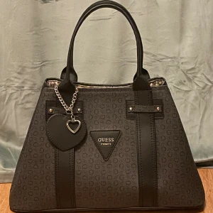 Handväska GUESS - Stor handväska som går att ha i två lägen och stängs med knapp+magnet. Leopardmönstrat foder & har små fickor.  Mått: ca 39x24x15 cm