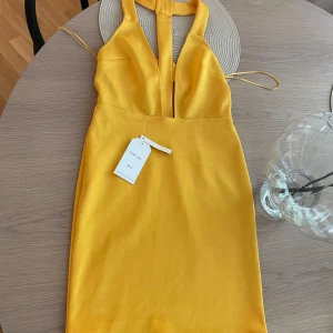 Gul sommarklänning  - Skitsnygg sommarklänning med en djup V-ringning köpt i London förra året, aldrig använd som ni ser på prislappen 😊 sitter som gjutet på, skitsnygg på någon som fått lite färg.