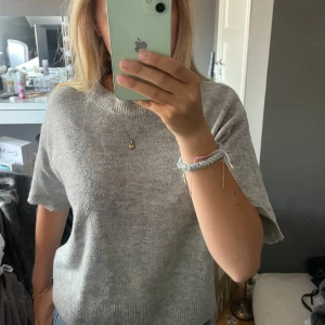 Grå stickad t shirt  - Säljer denna trekvartsärmade tröja då den inte längre kommer till användning. Bra skick.