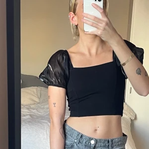 Crop top med puffärmar - Svart festtopp  Storlek: S